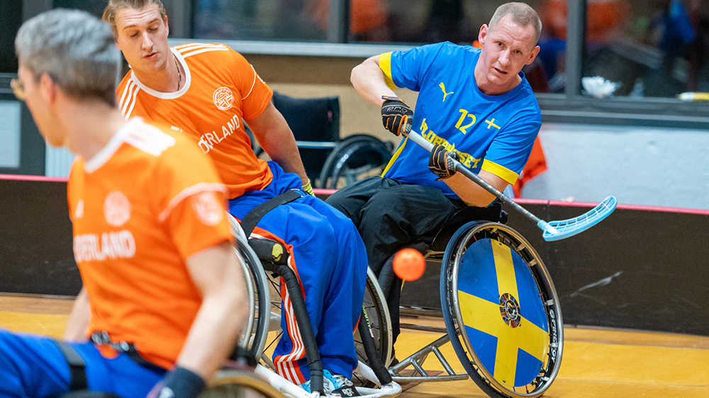 Rullstolsinnebandyspelare i action